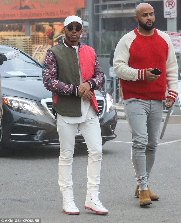 Colourful choice: Lewis opted to team a bold pink and olive bomber jacket, which featured floral print sleeves, with a white tee