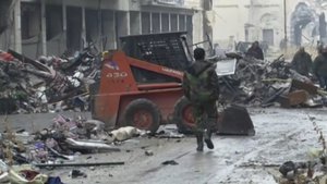 This frame grab  shows Syrian soldiers walking among damaged buildings on a street filled with debris near the ancient Umayyad Mosque, in the Old City of Aleppo, Syria.