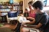 Sarah Nicholson  at home in Myrniong sitting on the couch reading to her two children.