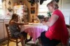 Samantha Rowe and her daughter Daisy sitting at the kitchen table reading.