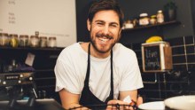 Portrait of happy barista at espresso bar.