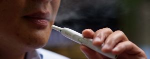 A man smokes a Philip Morris iQOS electronic cigarette in Tokyo