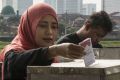 A woman casts her ballot in the election for Jakarta's governor on Wednesday.