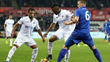 SWANSEA, WALES - FEBRUARY 12: Jordan Ayew of Swansea City is challenged by Robert Huth of Leicester City during the ...