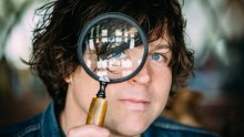 Ryan Adams looking through magnifying glass