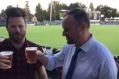 Chief Minister Andrew Barr skolls a beer in front of the Bob Hawke stand.