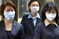 Office workers wear protective masks in downtown Hong Kong at the height of the SARS crisis in 2003.