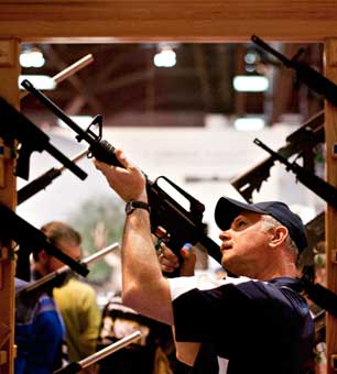 An attendee sights a rifle at a booth during the National Rifle Association annual convention in St. Louis, April 14, 2012. (Photo: Daniel Acker / The New York Times)