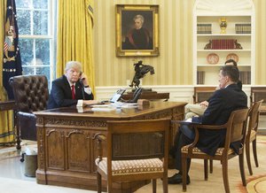 President Donald Trump, left, accompanied by National Security Adviser Michael Flynn, right, and Senior Advisor to the President Jared Kushner, speaks on the phone with King of Saudi Arabia Salman bin Abd al-Aziz Al Saud in the Oval Office at the White House in Washington, Sunday, Jan. 29, 2017.