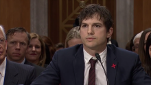 Ashton Kutcher sits behind a placard of his name, addressing the US Senate Committee ending modern slavery