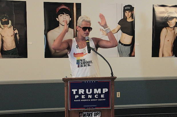 milo yiannopoulos stands a podium at an anti-Muslim, pro-Trump event