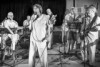 A band comprised of medical professionals rehearses in a black and white image.