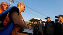 Thai police block Buddhist monks at the gate of Dhammakaya temple.