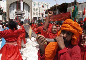 Devotees perform "dhamal" a devotional dance involving a frenzied and ecstatic swirl of the head and body, which is a special ritual that is performed at the rhythmic beat of traditional drums, during an anniversary of famous saint Lal Shahbaz Qalander at his shrine in Sewan Sharif, 250 kilometers (155 miles) from Hyderabad, Pakistan on Thursday, July 21, 2011.