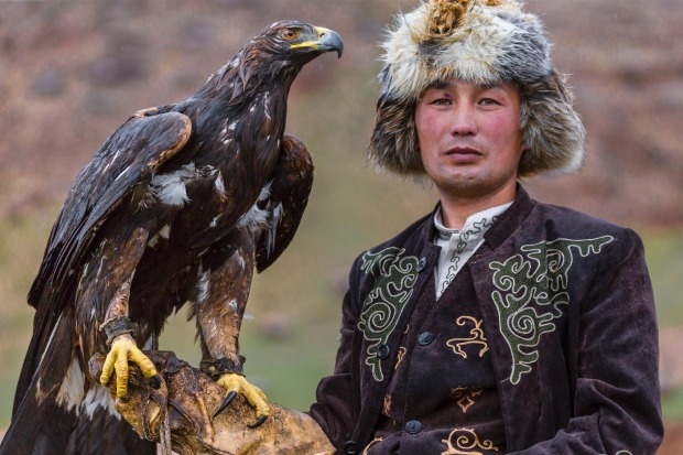 Issyk Kul, Kyrgyzstan: Eagle hunter holds his golden eagle.