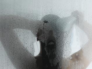 A female taking a hot steam shower.