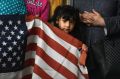 Maria Martinez, of Detroit, holds onto an American flag during a Michigan United press conference at its Detroit ...