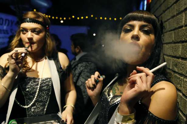 FILE - In this Dec. 31, 2013 file photo, partygoers smoke marijuana during a Prohibition-era themed New Year's Eve invite-only party celebrating the start of retail pot sales, at a bar in Denver. Colorado is on the brink of becoming the first state with licensed pot clubs. Denver officials are working on regulations to open a one-year pilot of bring-your-own marijuana clubs.