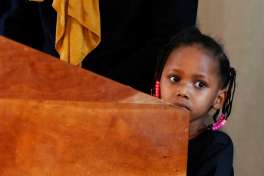 Four-year-old Somali refugee Mushkaad Abdi stands at the podium as her mother, Samira Dahir, addresses a Minneapolis news conference Friday, Feb. 3, 2017, one day after Mushkaad was reunited with family. Her trip from Uganda to Minnesota was held up by President Donald Trump's Jan. 27 order barring refugees from seven predominantly Muslim nations.