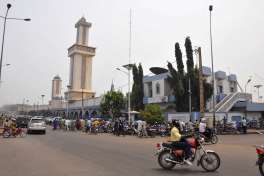 People, rear, gather outside Zogo Mosque for Friday afternoon prayers in Cotonou, Benin, Friday, Feb. 17, 2017. Tensions have mounted in Benin after authorities cleared illegal structures from sidewalks including temporary awnings beside mosques where large numbers of worshippers gather for Friday prayers.