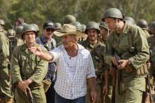 This image released by Summit shows director Mel Gibson, center, and actor Vince Vaughn on the set of the film, "Hacksaw Ridge." Gibson is nominated for an Oscar for best directing for his work on the film. (Summit via AP)