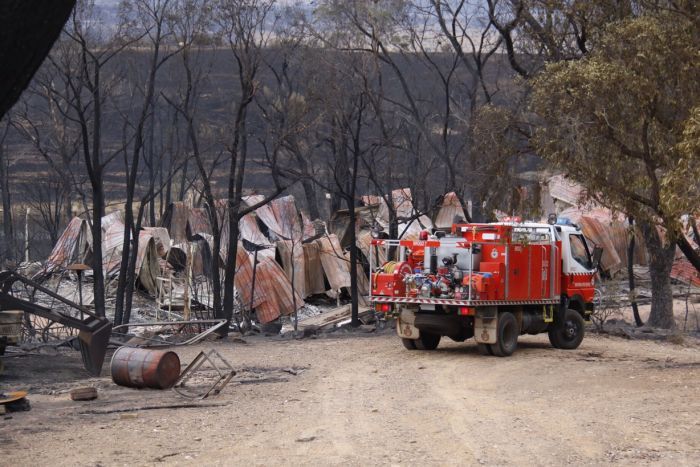 A fire engine in front of a burnt-out property near Carwoola.