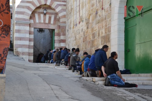 Palestinian men and boys, praying outside al-Ibrahimi mosque