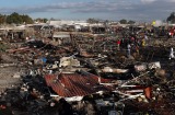 Firefighters and rescue workers walk through the scorched ground of Mexico's best-known fireworks market after an explosion.