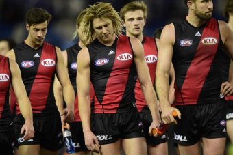 Dyson heppell leads Essendon players off the field after their loss to Western Bulldogs