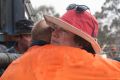 Vanessa Lindley is comforted by friends after her property is destroyed after a fast moving bush fire at Widgiewa Rd on ...