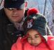 Asylum seeker children are helped into Canada by Royal Canadian Mounted Police officers along the US-Canada border near ...