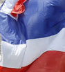 A Thai anti-government protester waves the Thai national flag during a mass rally to the Thon Buri side of the Chao Phraya river in Bangkok