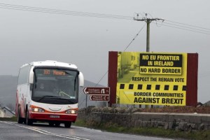 A bus crosses the border into Northern Ireland from the Irish Republic next to a poster protesting against a hard Brexit near Jonesborough on January 30, 2017, (PAUL FAITH/AFP/Getty Images)