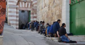 Palestinian men and boys, praying outside al-Ibrahimi mosque