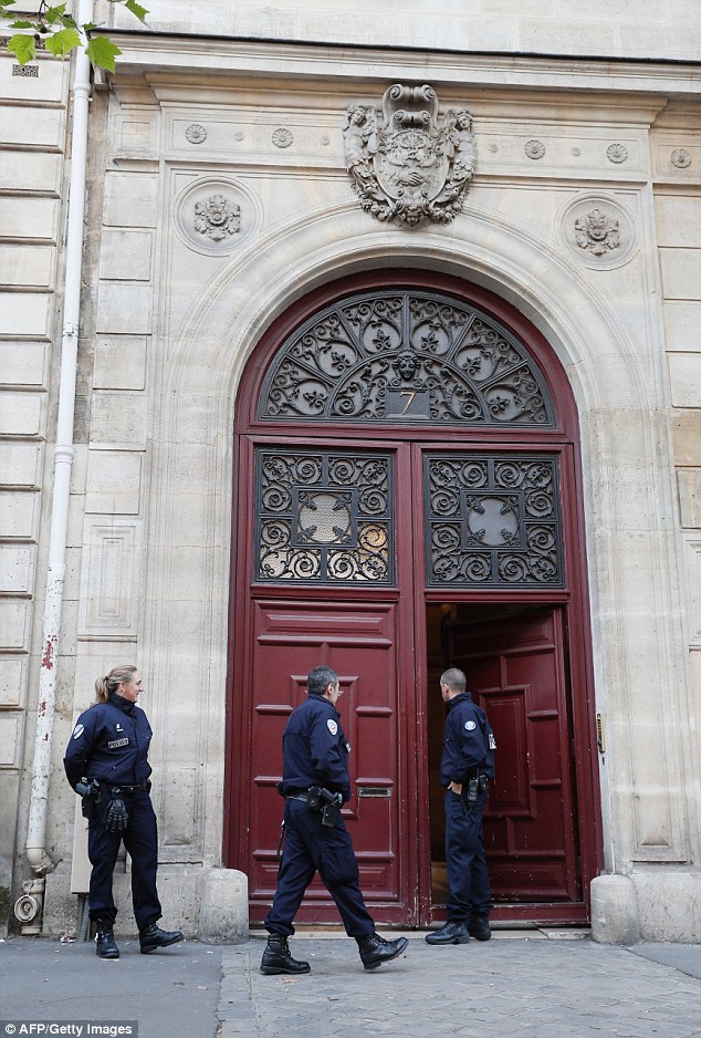 Police officers stand guard at the entrance to the hotel residence at the Rue Tronchet, near Madeleine, central Paris after the violent raid