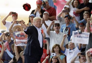 President Donald Trump throws a hat into the crowd during the "Make America Great Again Rally" at Orlando-Melbourne International Airport Saturday, Feb. 18, 2017, in Melbourne, Fla.