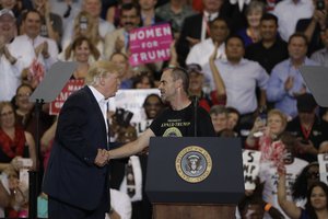 President Donald Trump with supporter Gene Huber during a campaign rally Saturday, Feb. 18, 2017, in Melbourne, Fla.