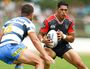 Roger Tuivasa-Sheck of the Warriors runs at Ash Taylor of the Titans.