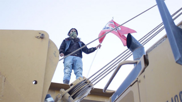 An Indigenous Water Protector occupies a sideboom, a machine used to lay pipe, January 7, 2017. (Photo: Garrett Graham)