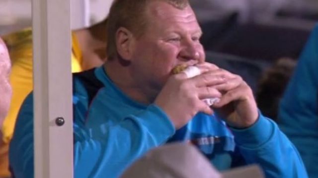 Tucking in: Wayne Shaw eats a pie in the dug-out during the game.