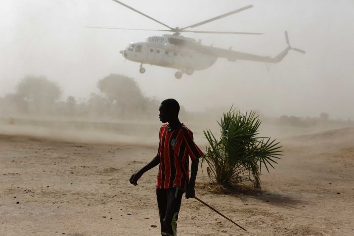 A World Food Program helicopter hovers close to the ground in South Sudan