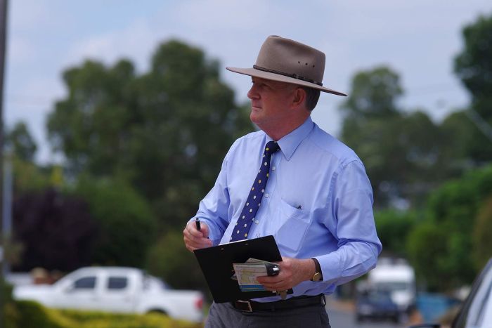 John Day pictured outside, holding a clipboard.