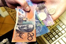 A shop assistant hands over change to a customer