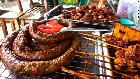 Throughout Chiang Mai, Thailand, street vendors hawk coils of herb-spiked sausages or sai ua.