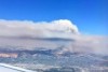 Smoke billows from a fire near Christchurch, as seen from a plane window.