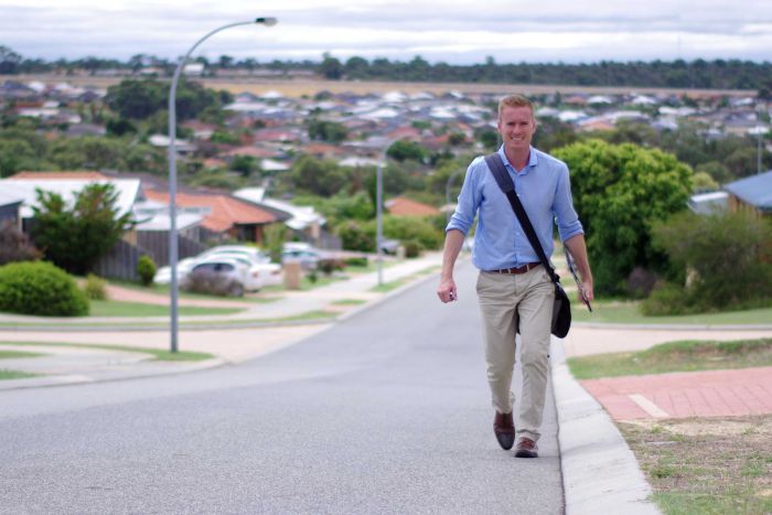 Albert Jacob walks along a suburban street.