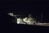 A floodlight helps illuminate a rural property near Gunning, NSW where three people were found dead at the bottom of a tank.