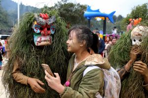  Young men dressed as Manggao (God of Mountain in Miao nationality) send blessing to people during the Manggao Festival ...