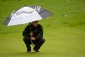 Adam Scott lines up a putt on the fourth.