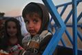 An Iraqi boy who fled with his parents from fighting between Iraqi forces and Islamic State militants, sits on a pickup ...